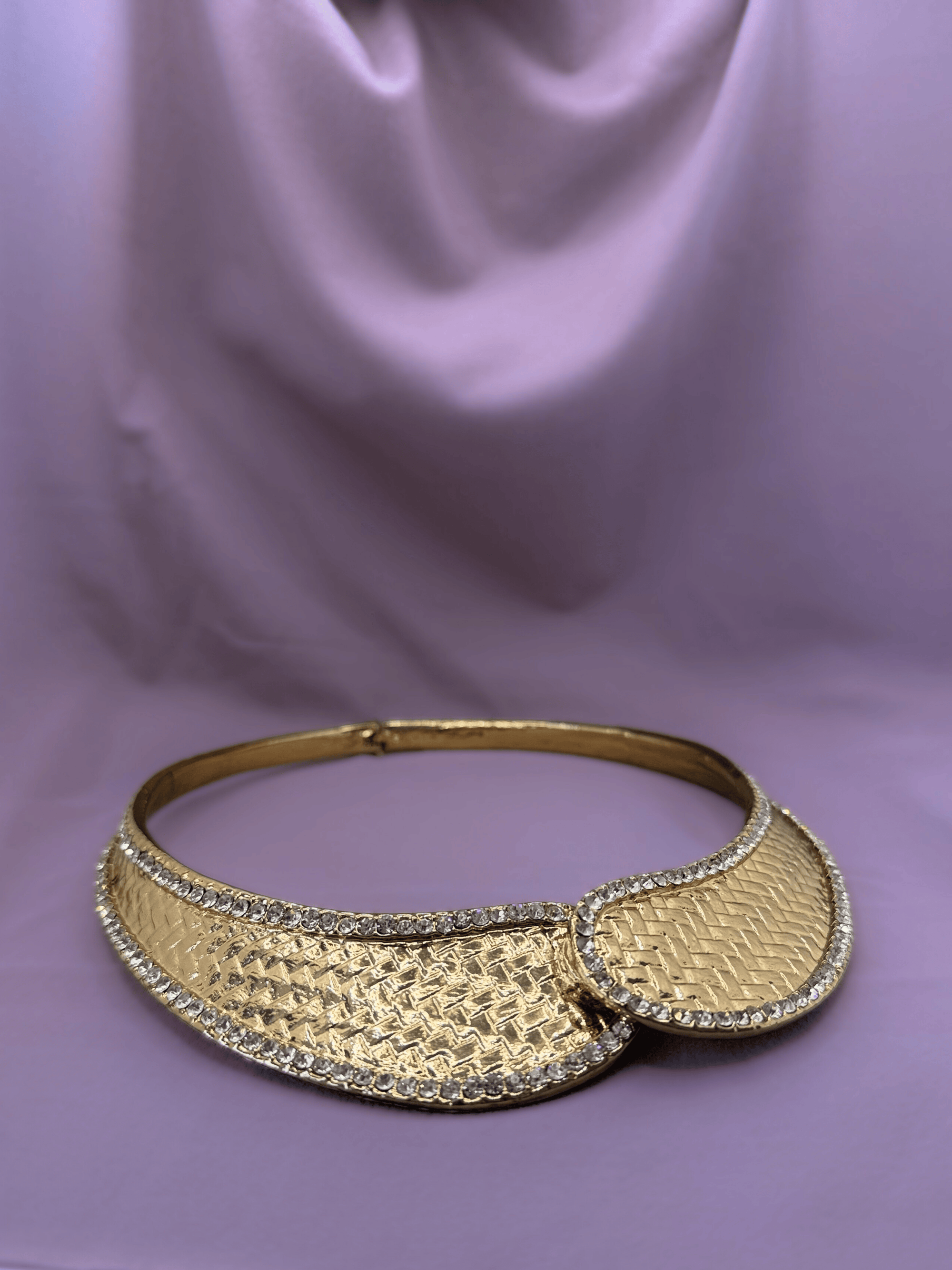 Gold necklace on a purple fabric background
