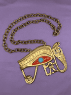 Gold necklace with an eye design on a purple background