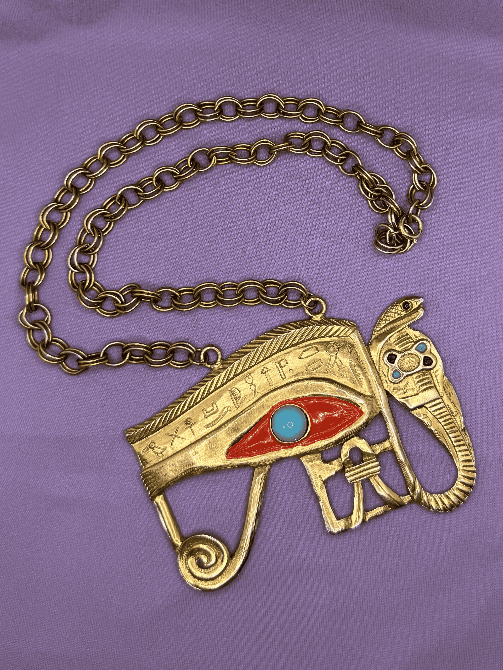 Gold necklace with an eye design on a purple background